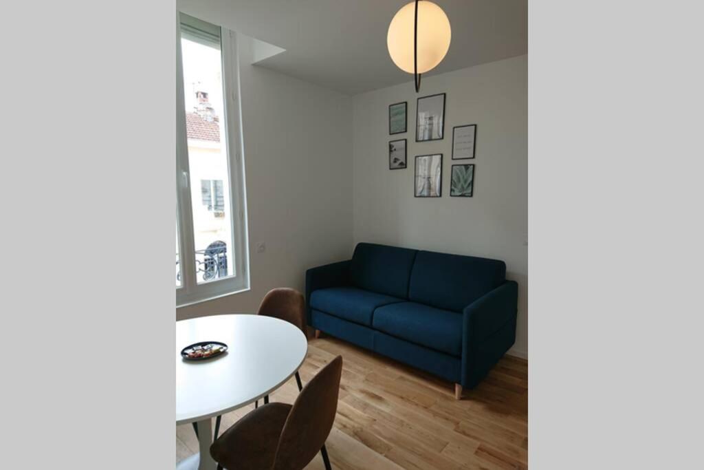 - un salon avec un canapé bleu et une table dans l'établissement appartement 4 pers quartier Chartrons à Bordeaux, à Bordeaux