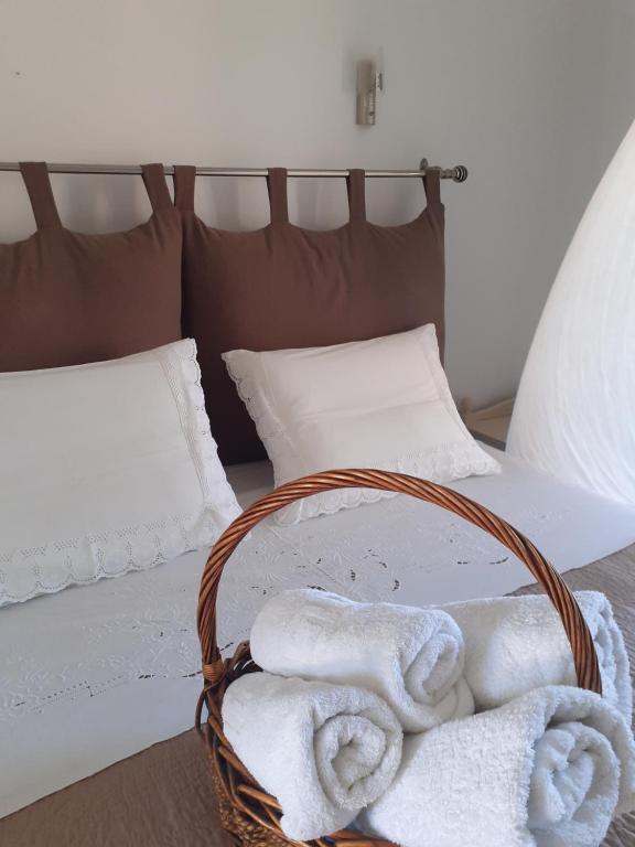 a basket of towels sitting on a bed at Marili Apartments in Roda