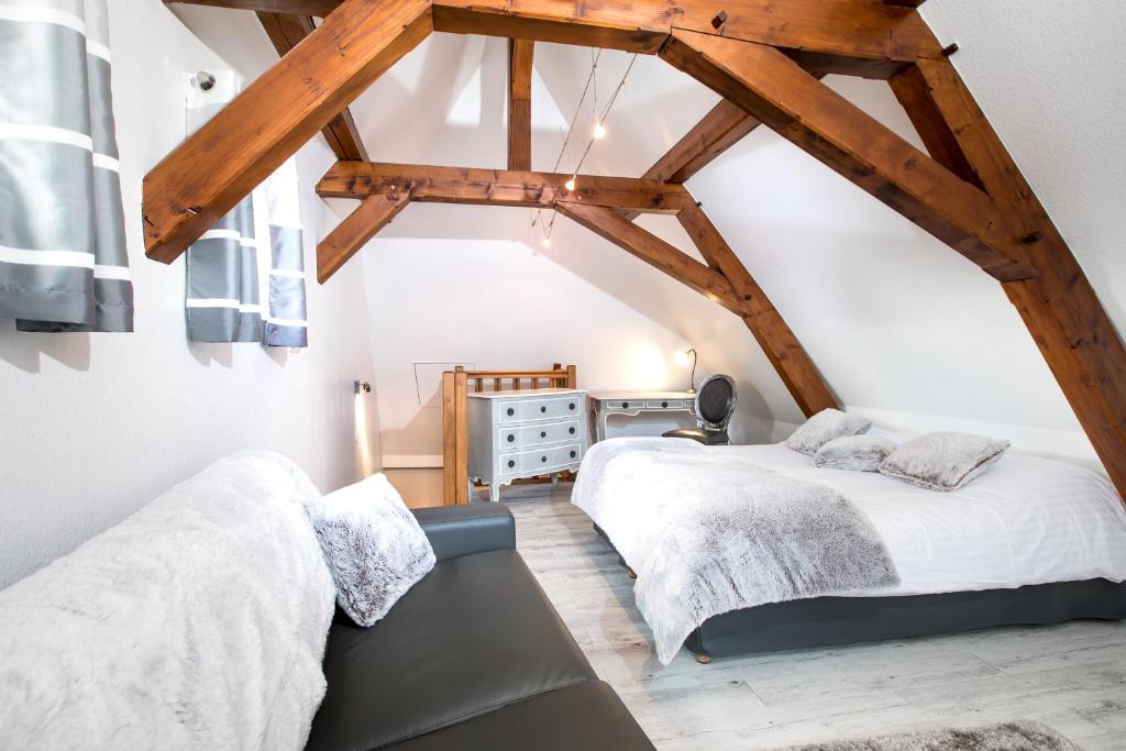 two beds in a attic room with wooden beams at My Sweet Homes - Le 15 in Colmar