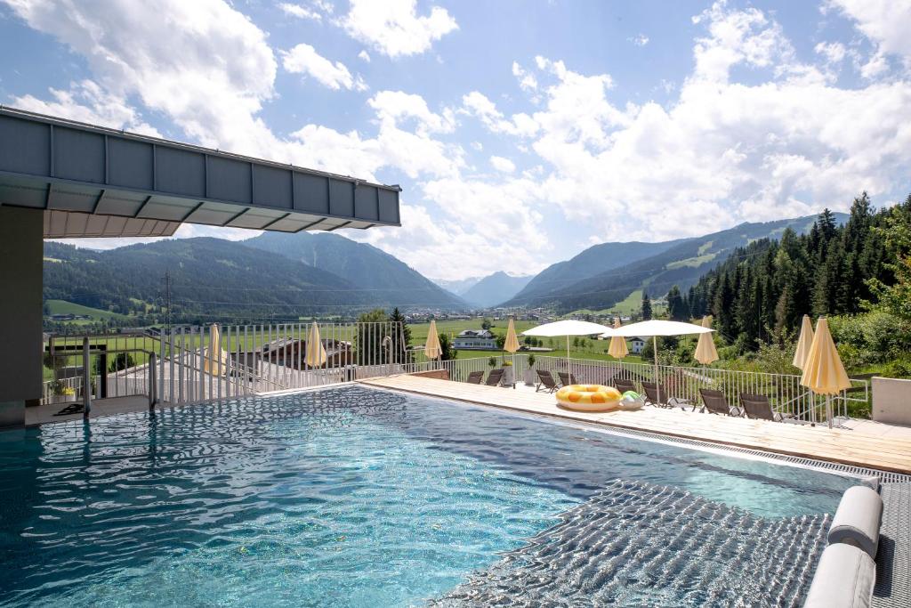 a swimming pool with a view of mountains at Familienhotel Felsenhof in Flachau