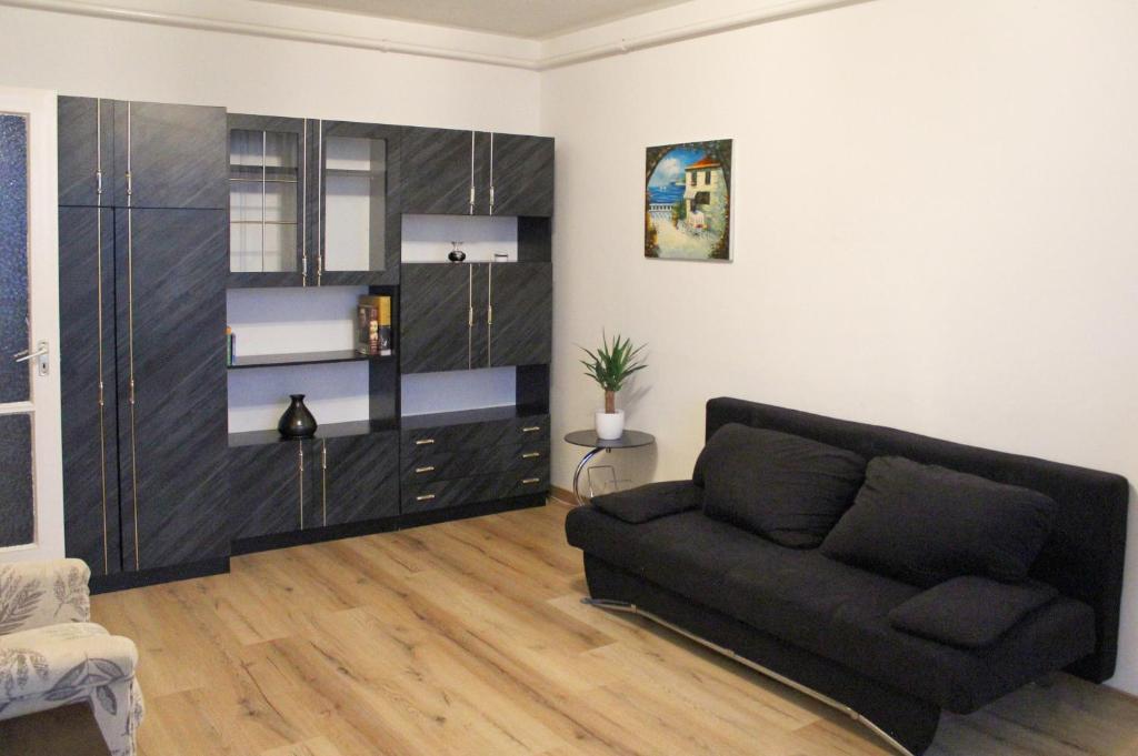 a living room with a black couch in a room at Sunset-view Apartment in Debrecen