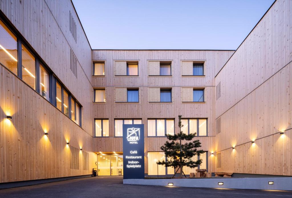 a building with a sign in front of it at JUFA Hotel Laterns - Klangholzhus in Laterns