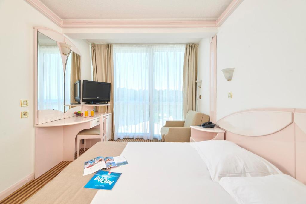 a hotel room with a bed and a tv at Hotel Zorna Plava Laguna in Poreč