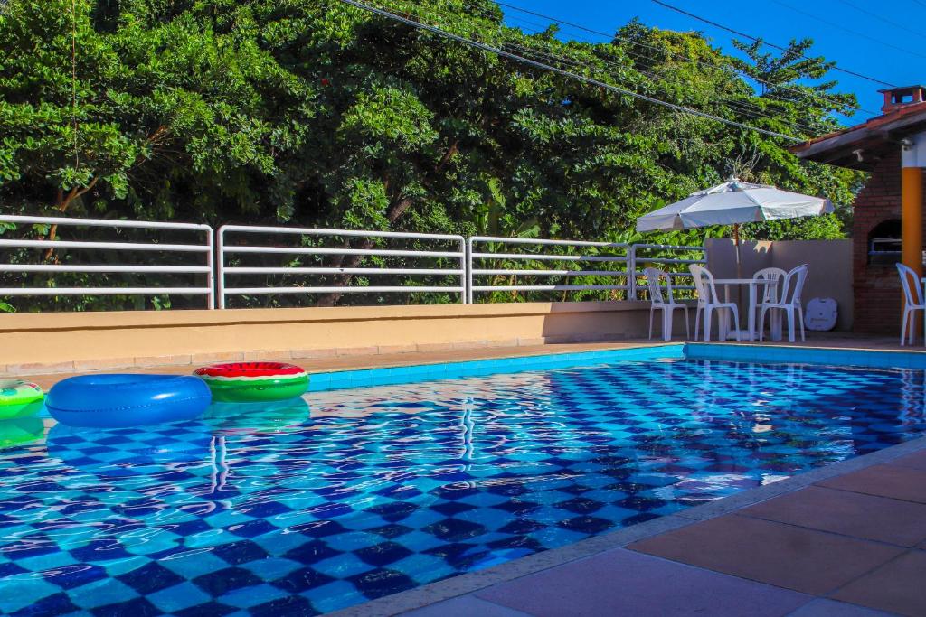een zwembad met stoelen en een parasol ernaast bij Mestre Lord Apart Hotel in Porto Seguro