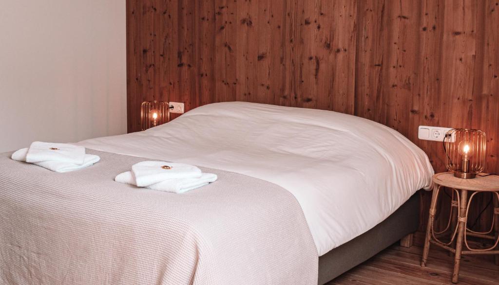 een slaapkamer met 2 bedden met witte lakens en houten wanden bij Friese Hoeve Sneek in Sneek