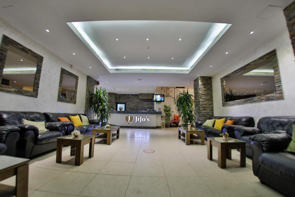 a lobby with couches and tables in a building at Jijo's Hotel in Mamaia