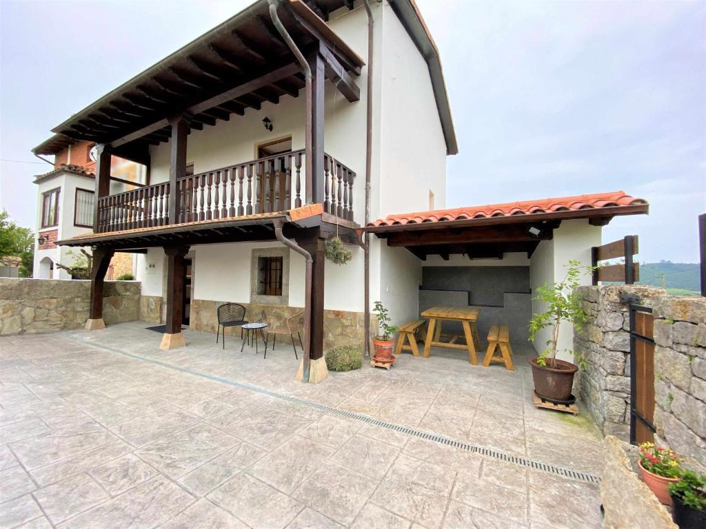 ein Haus mit einem Balkon und einem Tisch auf einer Terrasse in der Unterkunft La Finca de Ribadedeva in Colombres