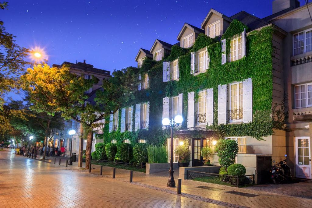 a building covered in green ivy at night at Hotel Boutique Le Reve in Santiago
