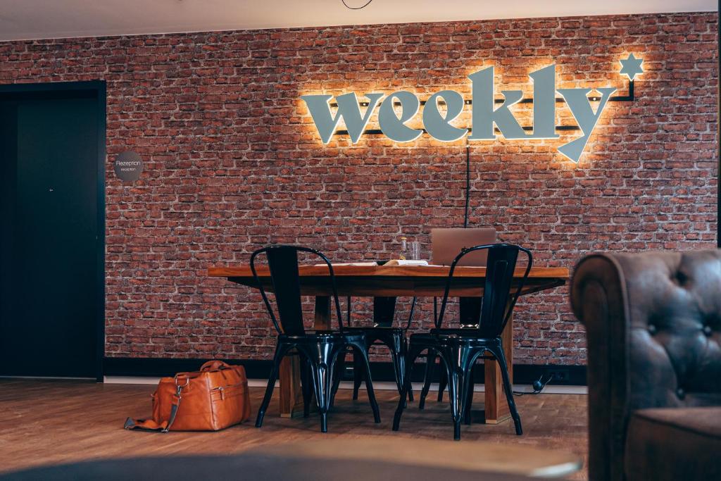 eine Ziegelwand mit einem Holztisch und Stühlen in der Unterkunft Weekly Boardinghouse in Lohr