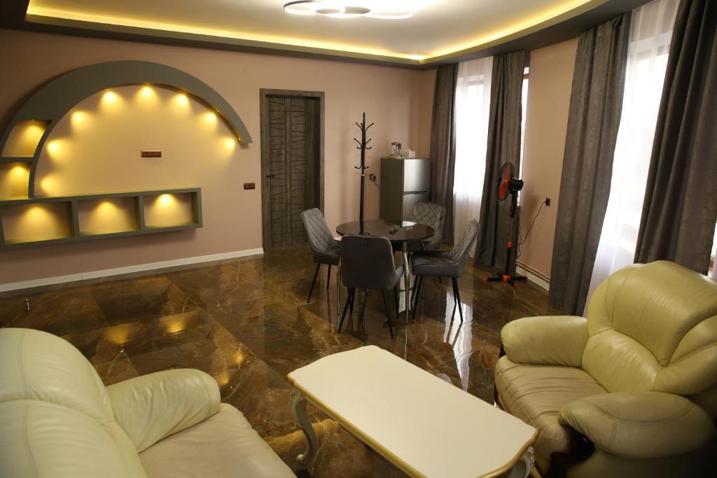 a living room with couches and a table and chairs at Hotel Gold in Gyumri