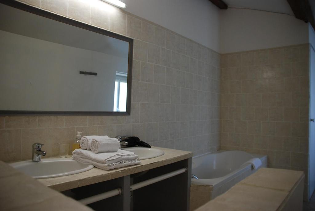 a bathroom with a sink and a tub and a mirror at Champ Fleuri in Angoulême