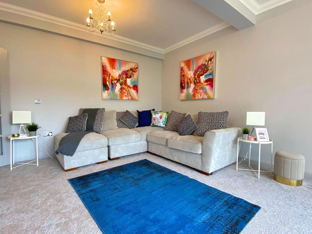 a living room with a couch and a blue rug at Beautiful Large 4 bedroom House - 5 Minute Walk to the Best Beach! - Great Location - Garden - Parking - Fast WiFi - Smart TV - Newly decorated - sleeps up to 10! Close to Bournemouth & Poole & Sandbanks in Bournemouth