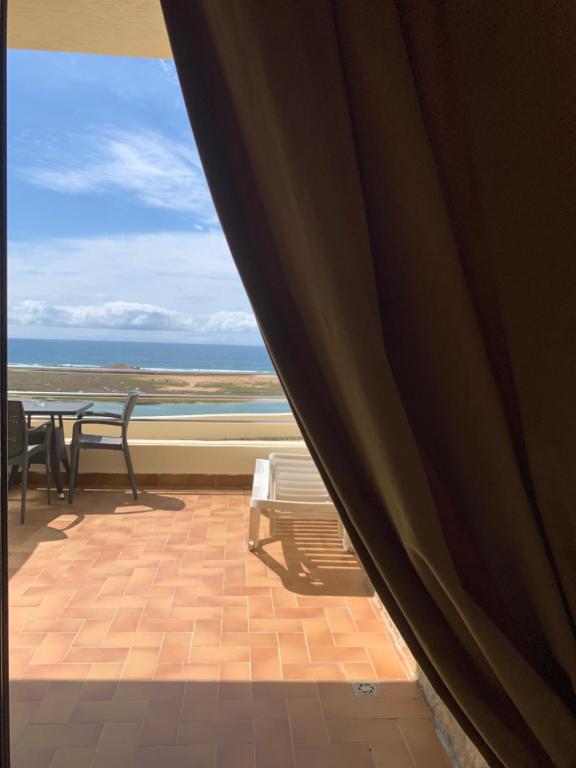 a balcony with a table and chairs and a view of the ocean at Auberge Oualidia Dream in Oualidia
