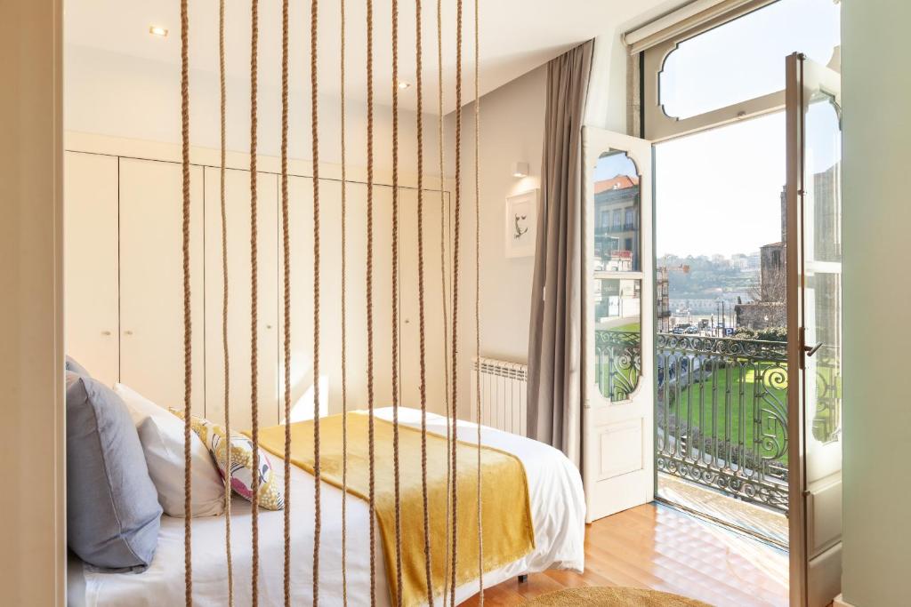 a bedroom with a swinging bed and a balcony at D&S - Ribeira Premium Apartments in Porto
