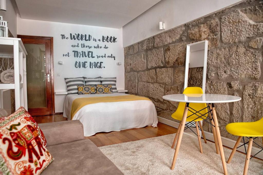 ein Schlafzimmer mit einem Bett und einer Steinmauer in der Unterkunft Try Oporto - Ribeira in Porto