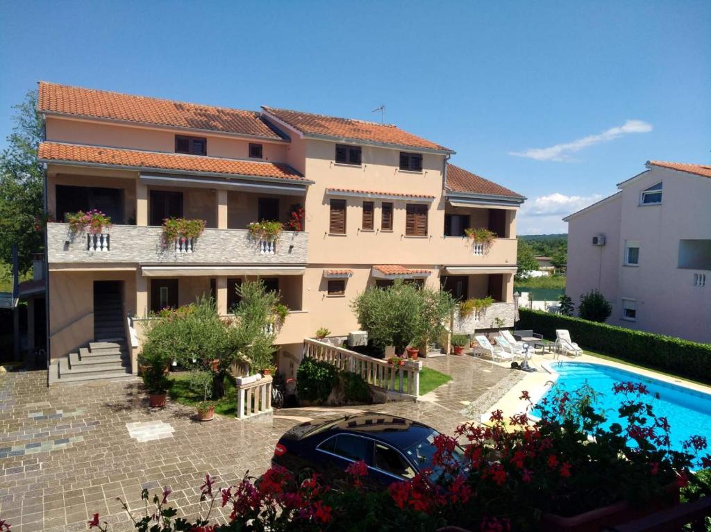une villa avec une piscine et une maison dans l'établissement Apartments Popović, à Funtana