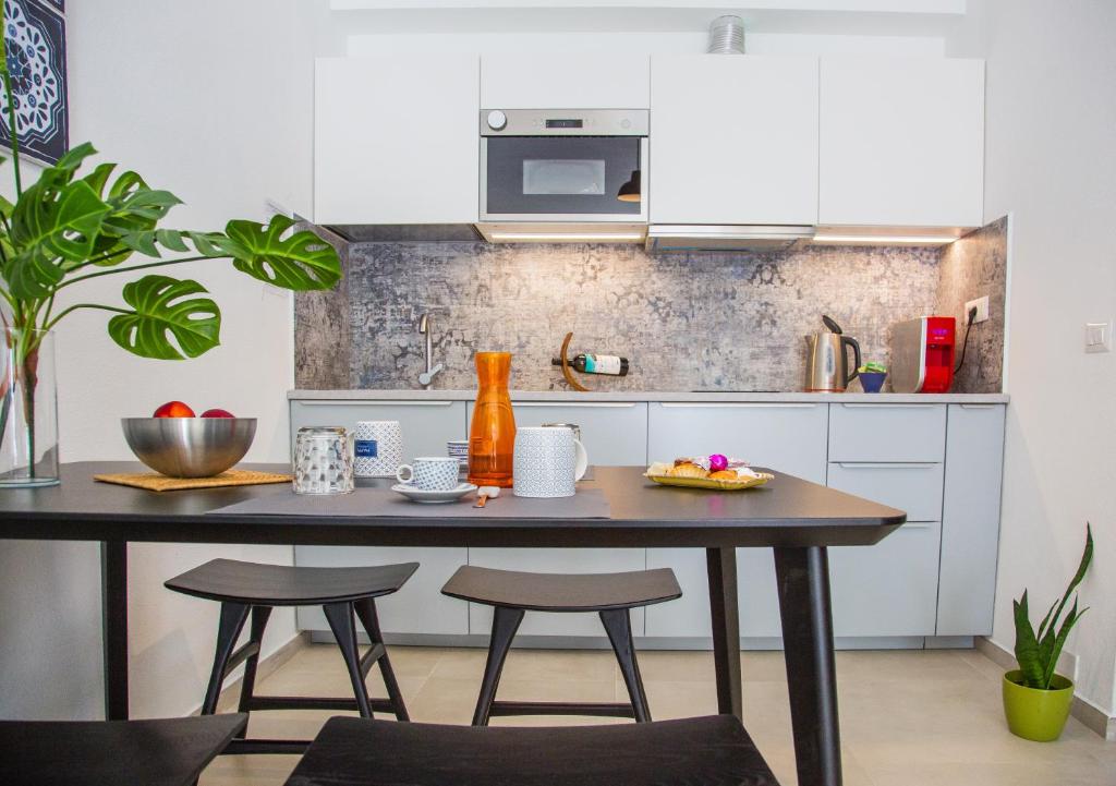 a kitchen with a table and two stools at Meduse Holiday IUNQ5361 in Cala Gonone