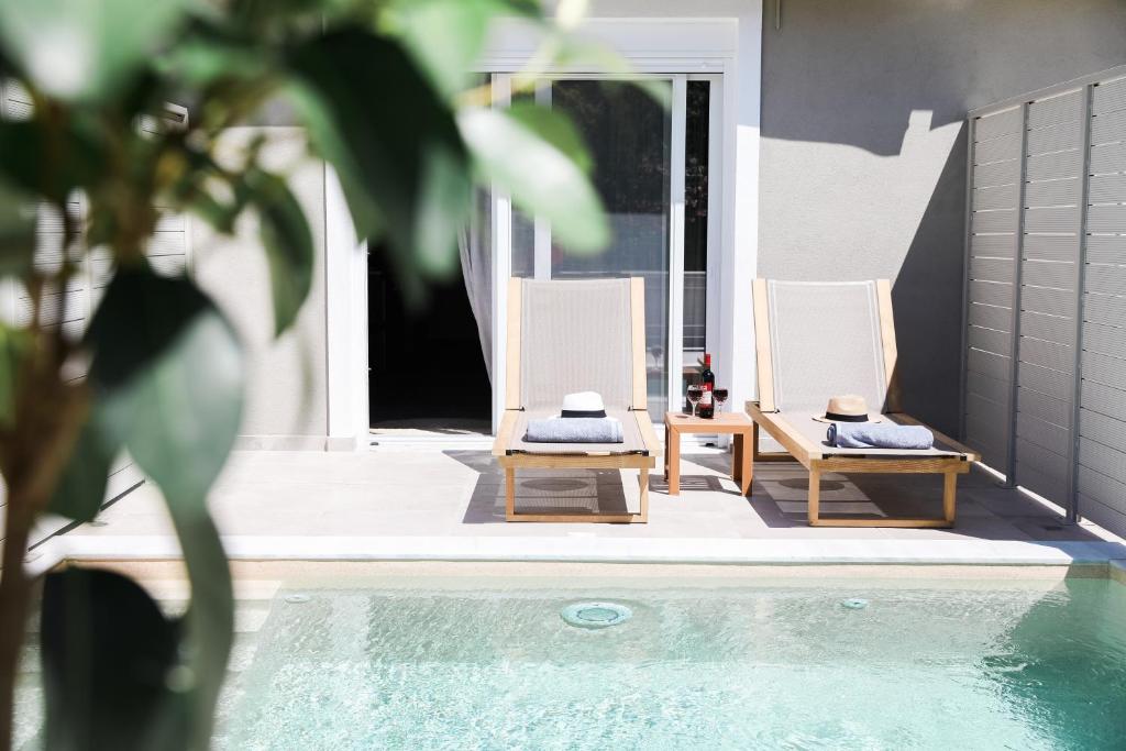 two chairs sitting next to a swimming pool at Comodo in Nydri