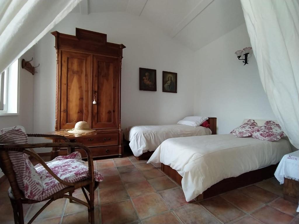 a bedroom with two beds and a chair in it at Casa Vacanze "I Casali" in San Giovanni in Galdo