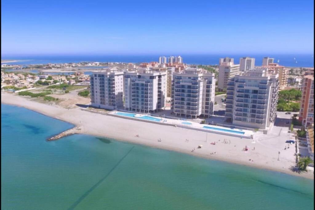 - une vue aérienne sur une plage avec des bâtiments et l'océan dans l'établissement La Manga Beach Club- LMHA 07, à La Manga del Mar Meno