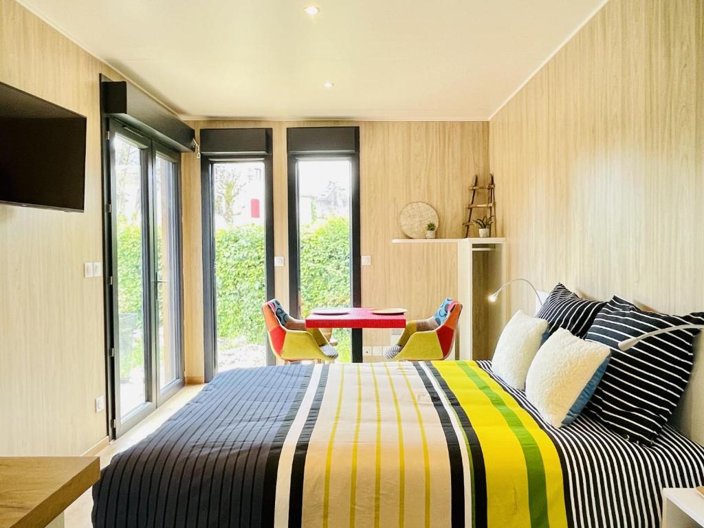 a bedroom with a bed and a table and chairs at Cabane de Rafael in Vittel