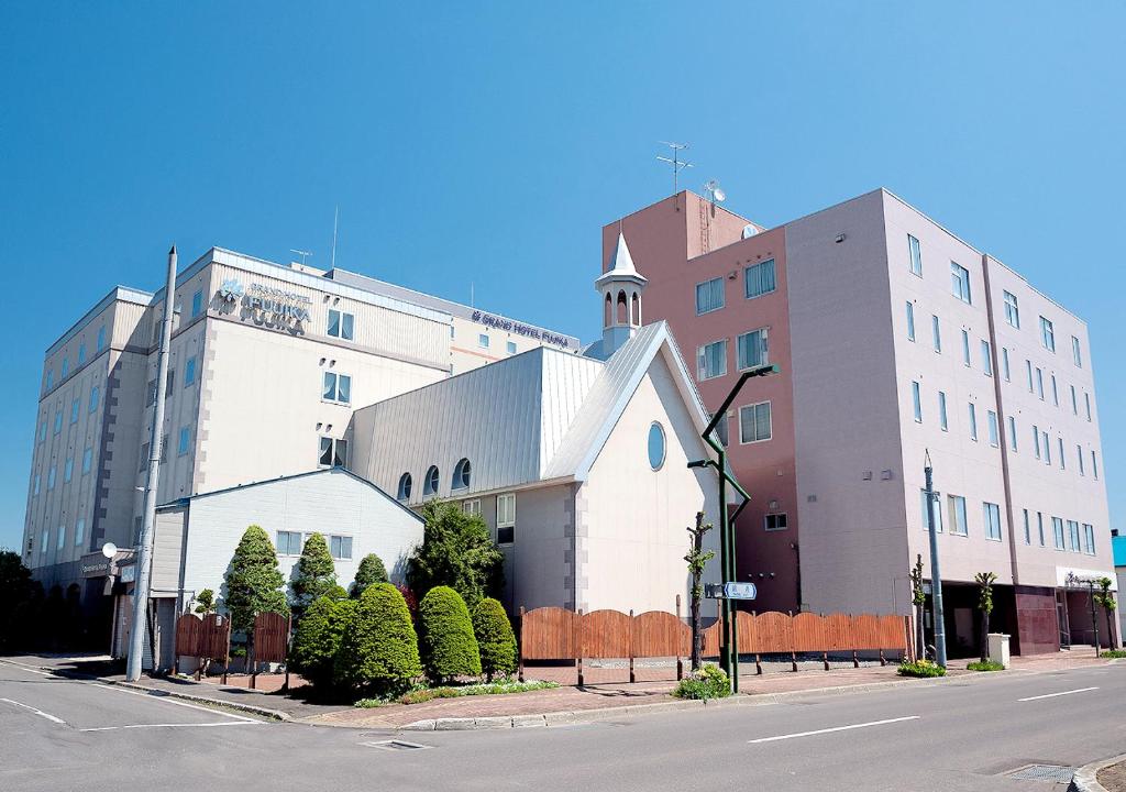 un grande edificio bianco sul lato di una strada di Grand Hotel Fujika a Nayoro