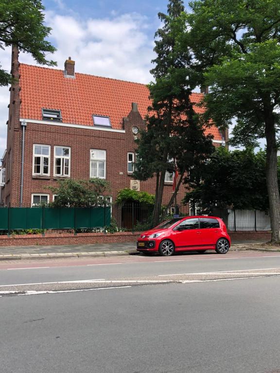 a red car parked on the side of a street at B&B Bommelsteijn in Dordrecht