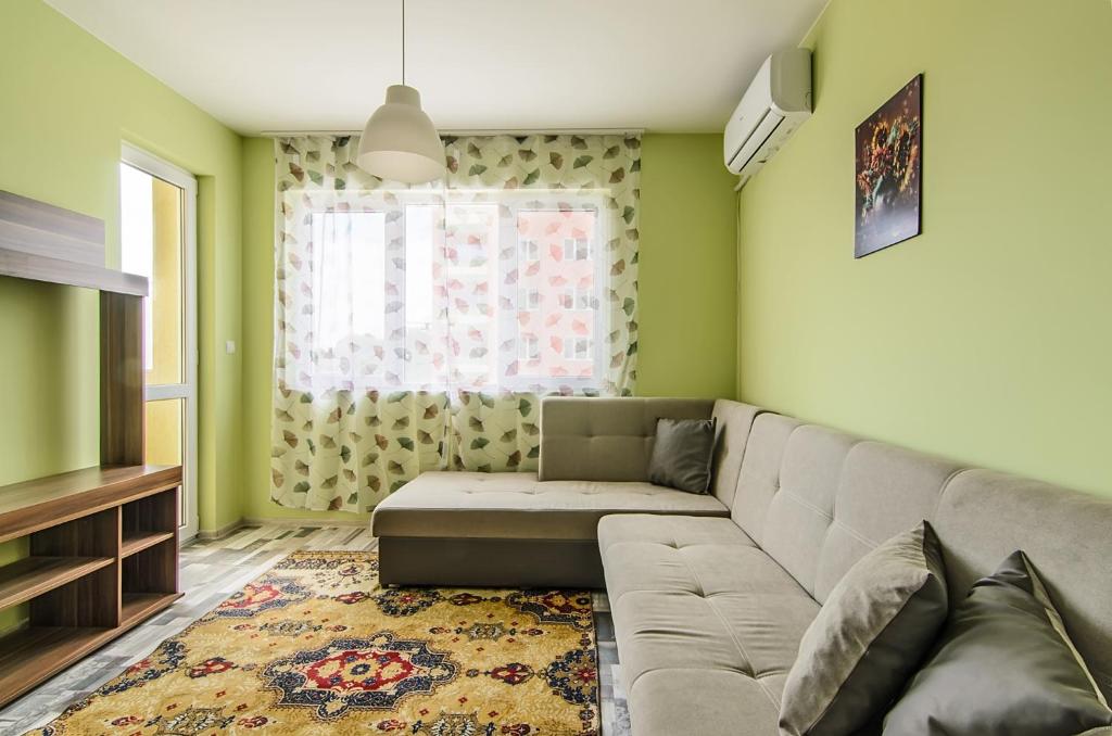 een woonkamer met een bank en een raam bij Apartment Sanik in Varna