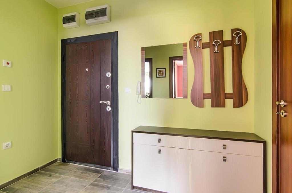 a room with green walls and a door with mirrors at Apartment Sanik in Varna City