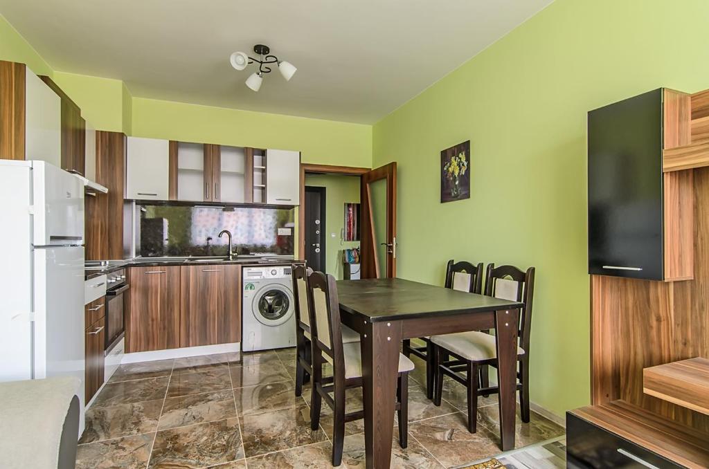 a kitchen with a dining room table and a kitchen with a washer at Apartment Sanik in Varna City