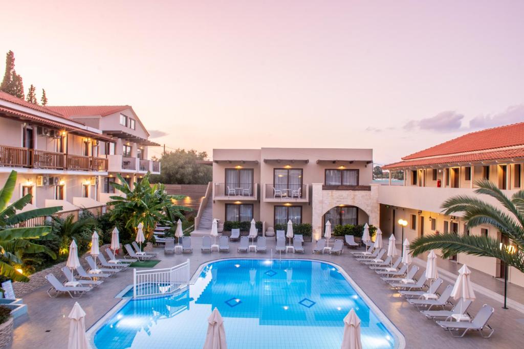 ein Bild eines Hotels mit Pool und Stühlen in der Unterkunft Lazaros Hotel Resort in Planos