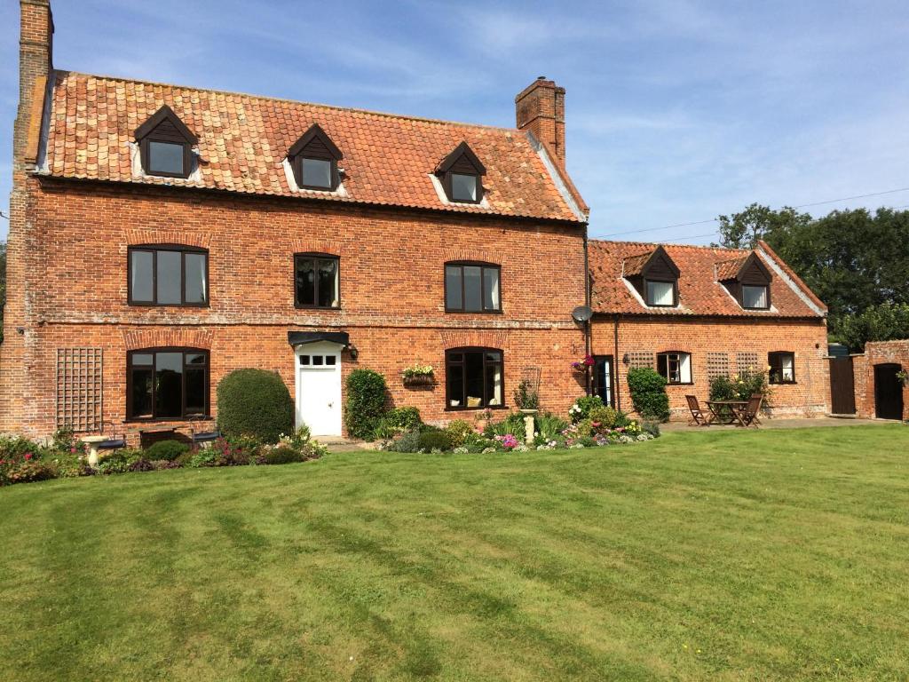 a large brick house with a large yard at Dairy Cottage in Cockley Cley