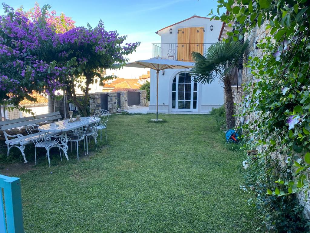un jardín con mesa y sillas en el patio en Villa St. Georges, en Piran