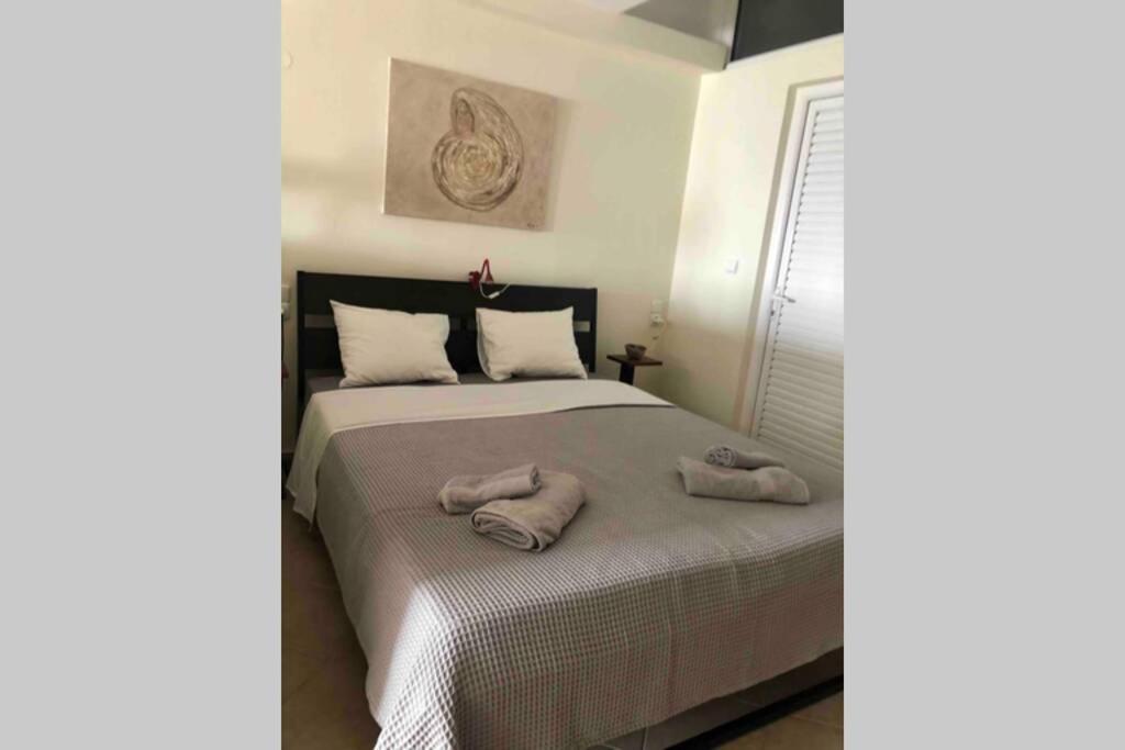 sypialnia z łóżkiem i dwoma ręcznikami na nim w obiekcie Cozy seafront loft - Kat's rentals w mieście Loutsa
