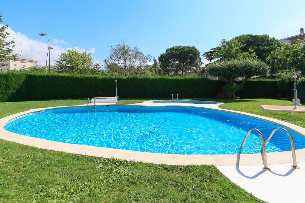 basen w trawie z ławką w środku w obiekcie UHC STELLA MARIS APARTMENTS w mieście Cambrils