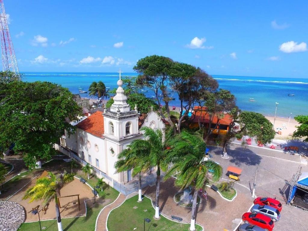 an aerial view of a church in front of the ocean at Lindo Flat Mar Azul em São José da Coroa Grande, Pernambuco in São José da Coroa Grande