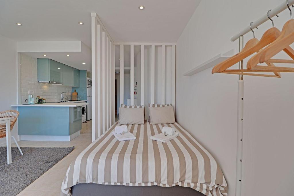 a bedroom with a striped bed in a kitchen at Quinta do Lago Victory Village with Pool by Homing in Quinta do Lago