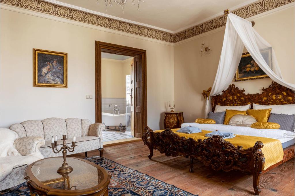 a bedroom with a king sized bed and a couch at Ambrožův dvůr in Pouzdřany