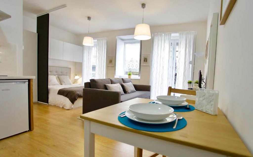a kitchen and living room with a table with plates on it at D&S - Porto São Bento Apartments II in Porto