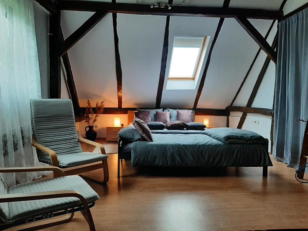um quarto com uma cama, uma cadeira e uma janela em HIŠA VILMOŠ / HOUSE VILMOŠ em Prosenjakovci