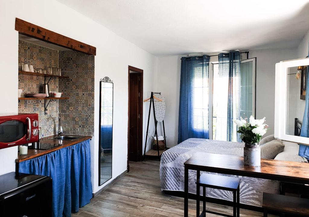 1 dormitorio con cama, mesa y lavamanos en Estudio Capricho, en Vejer de la Frontera