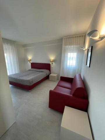 a bedroom with a bed and a couch and a chair at Casa Plauto SUITE senza cucina without kichen in Bellaria-Igea Marina
