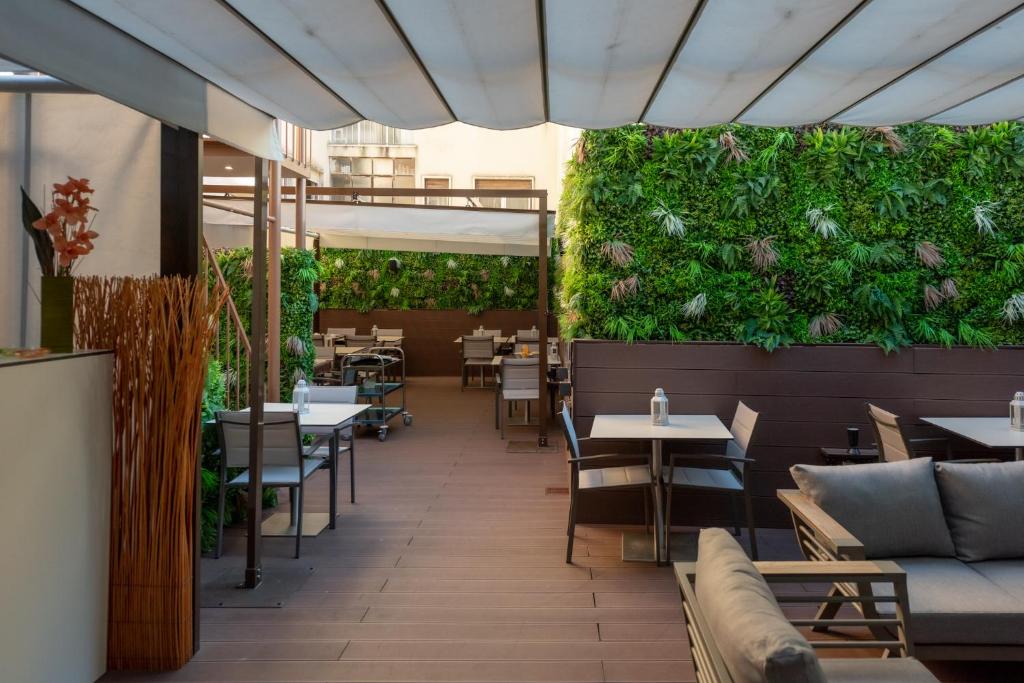 a patio area with tables, chairs and umbrellas at Dinya Lisbon Hotel & Lounge Bar in Lisbon