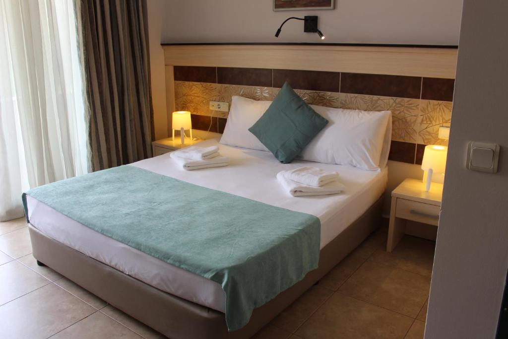 a bedroom with a large bed with two candles on it at Avlu Hotel in Kemer