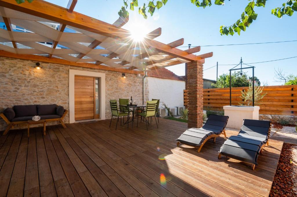 a patio with a wooden deck with a wooden pergola at Villa Perliano in Sukošan