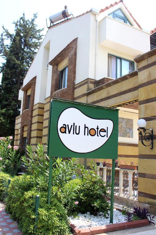 ein Schild für ein Hotel vor einem Gebäude in der Unterkunft Avlu Hotel in Kemer