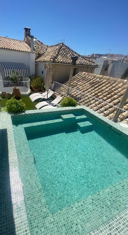 a swimming pool with blue water in front of a house at Hotel Don Juan Boutique in Úbeda