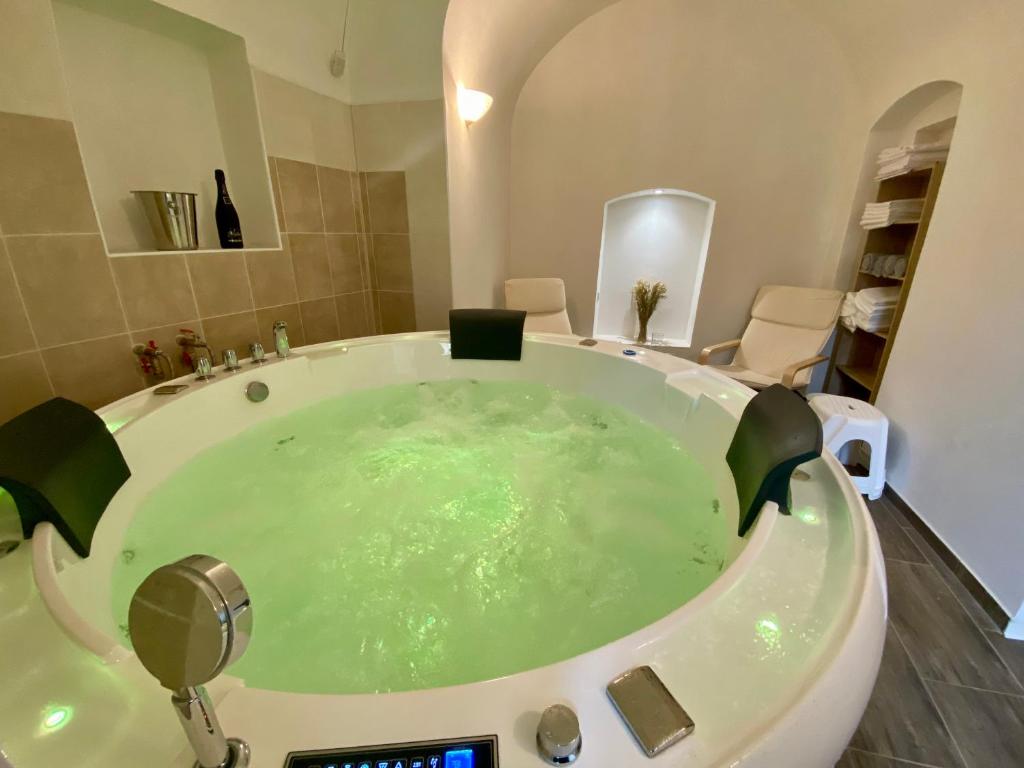 y baño con bañera llena de agua verde. en Mlýnský dům, en Hroznětín