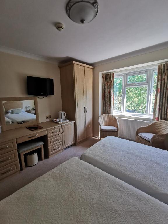 a hotel room with a bed and a television at The Grove Hotel in Bournemouth