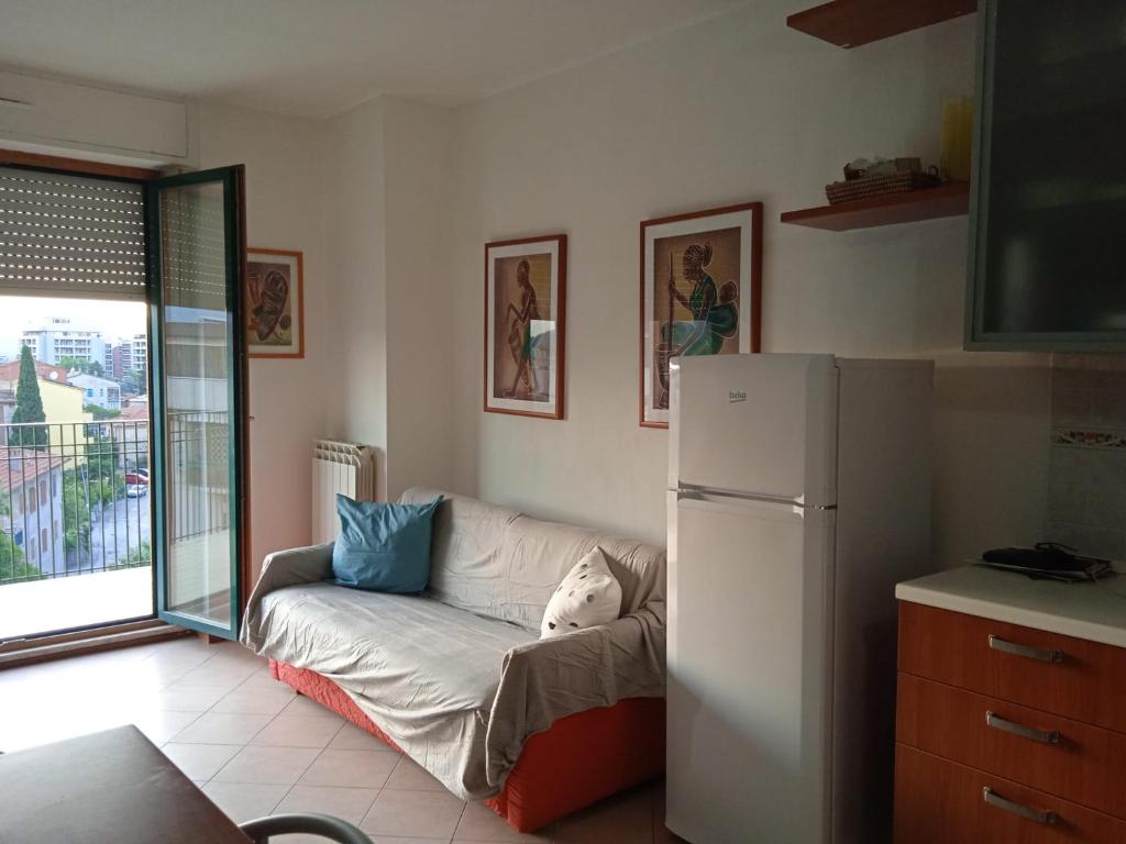 ein Wohnzimmer mit einem Sofa und einem Kühlschrank in der Unterkunft appartamento panoramico in Perugia